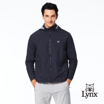 【Lynx Golf】男款防風防潑水反光斜紋造型Lynx左肩針織帶剪接設計拉鍊口袋長袖可拆式連帽外套-深藍色